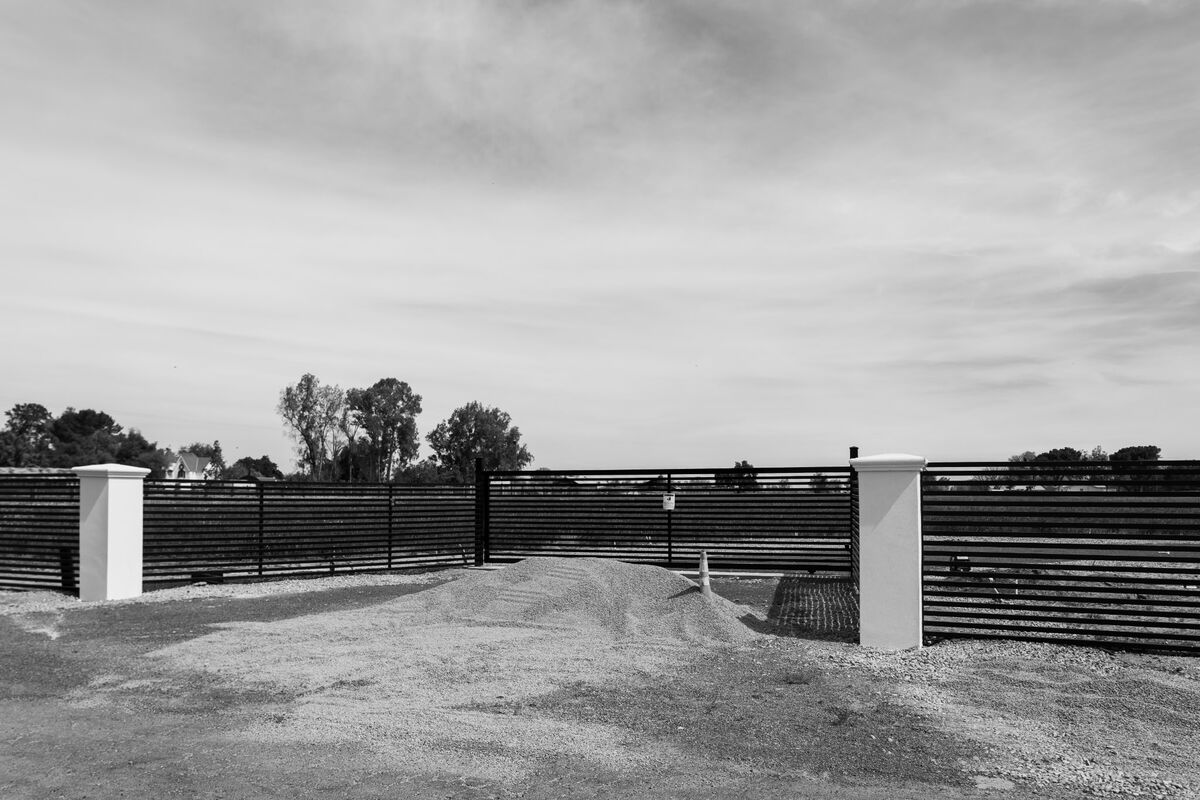 Custom sliding driveway gate and horizontal-slat fence at a Sacramento property