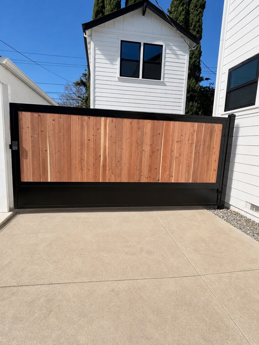 Double redwood driveway gate set in a black steel frame