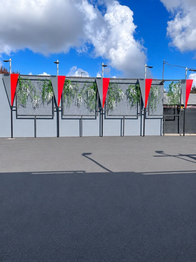 Steel screen wall with greenery panels at a commercial storefront