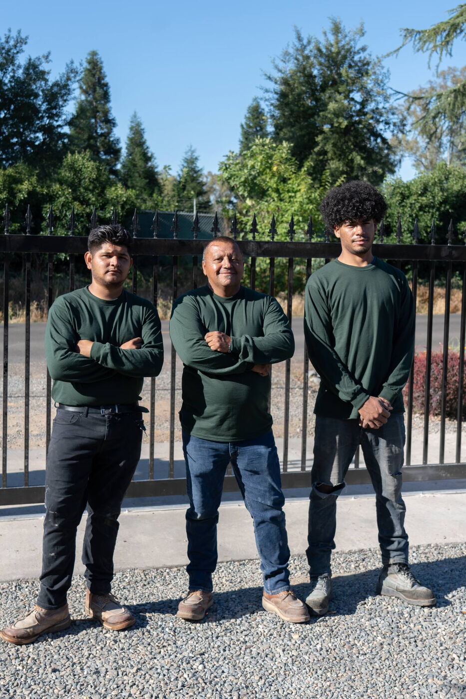 The Iron Caz Fencing crew standing in front of a custom wrought iron gate in Sacramento