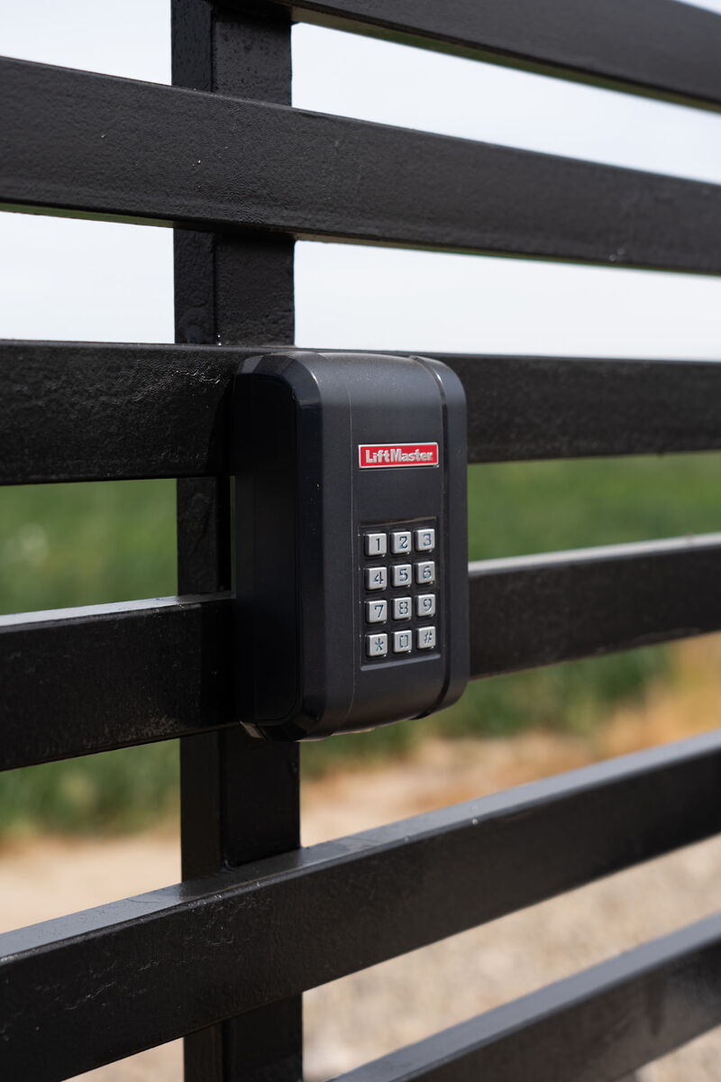 LiftMaster keypad access control mounted on a black steel driveway gate