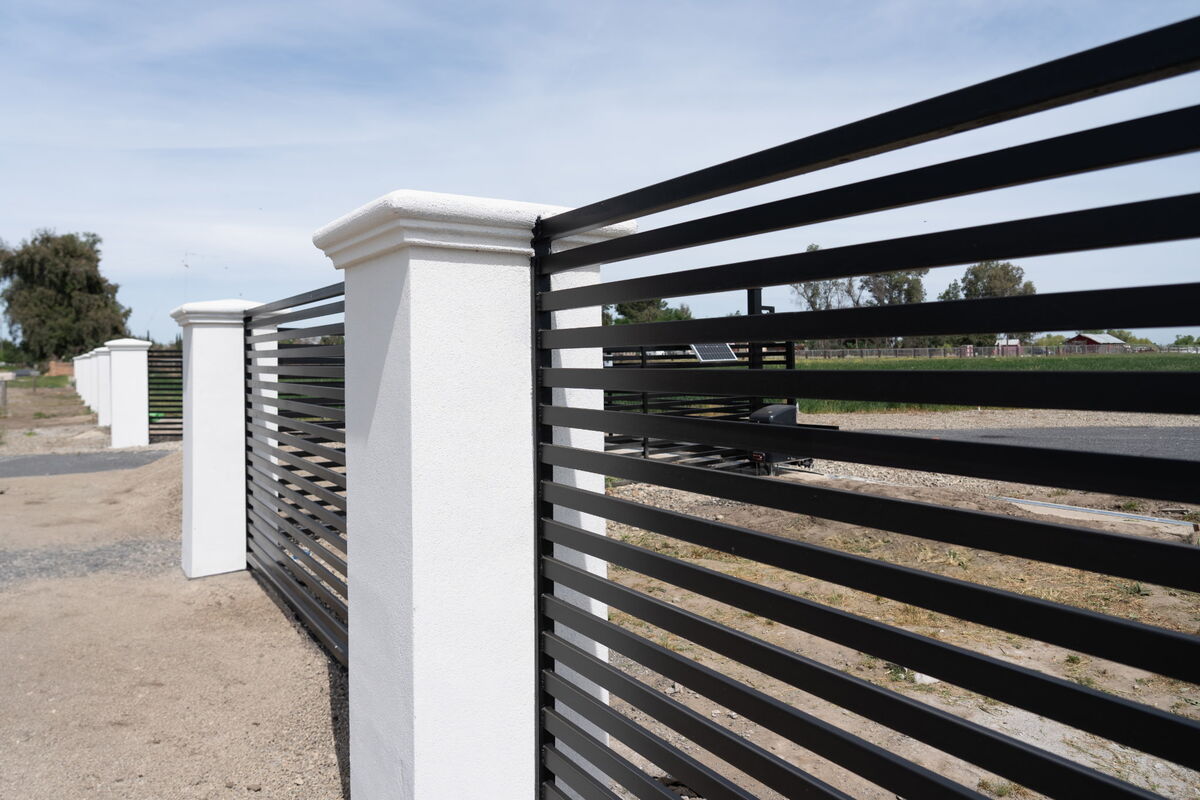Close-up of powder-coated horizontal slats meeting a white stucco column